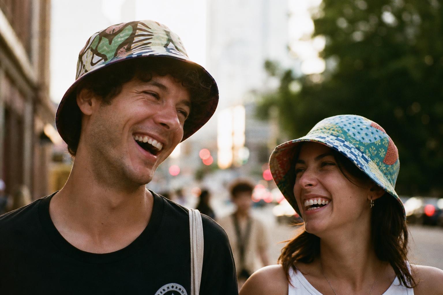 Two friends laughing outdoors in colorful Bizzare Buckade bucket hats